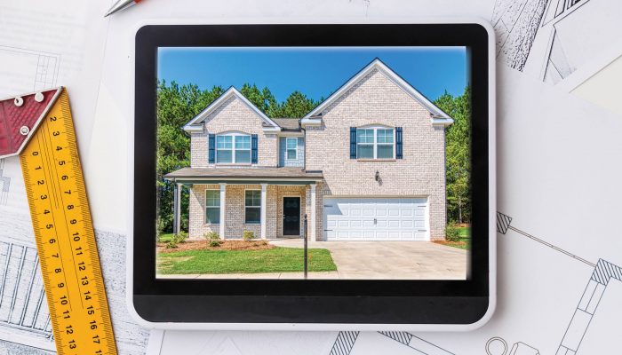 Home displayed on a tablet screen next to a ruler and blueprint