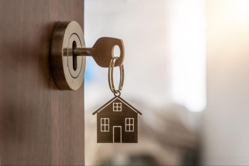 Key opening a new house with a house key chain ©Michael Dechev