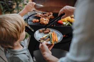 dad and son grilling on the grill ©Halfpoint