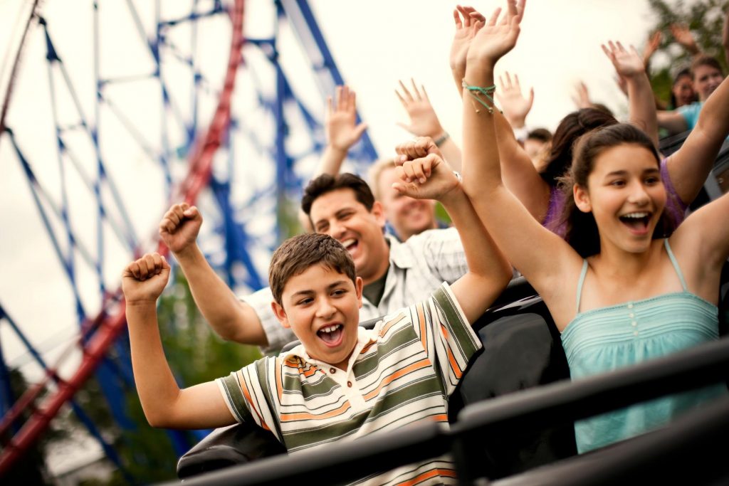 a group of people throwing their hands up on a roller coaster ©Erickson Stock