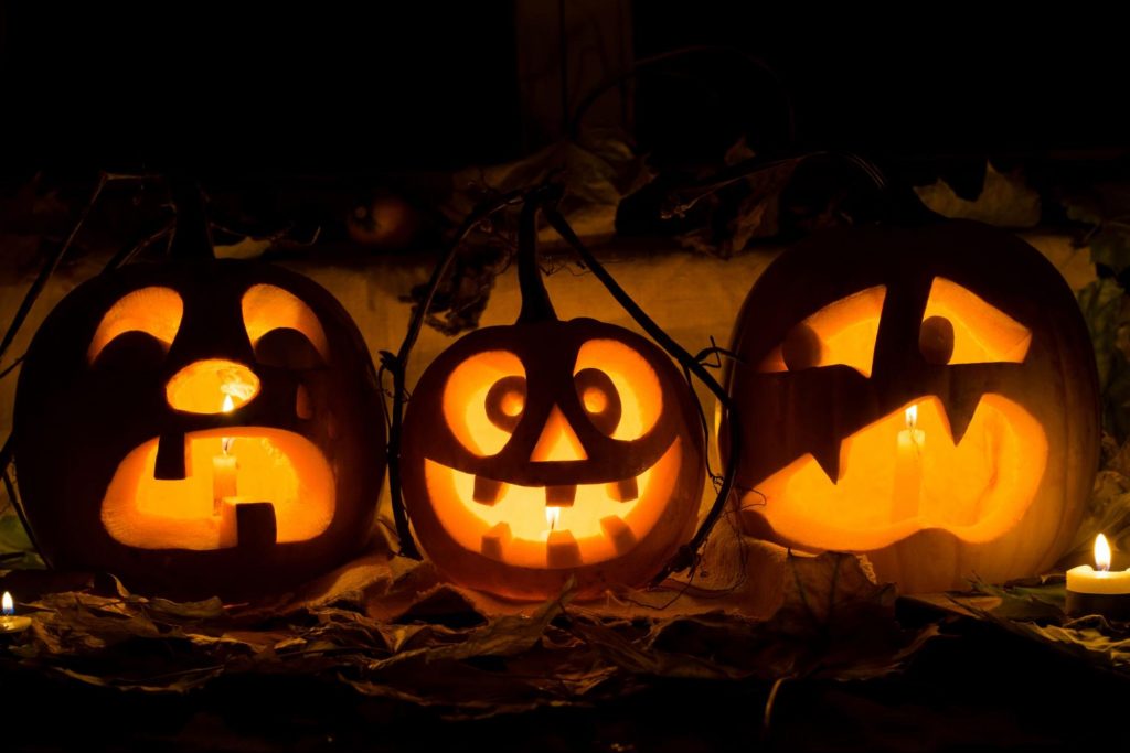 Lit carved pumpkins outside at night.
©Richman21