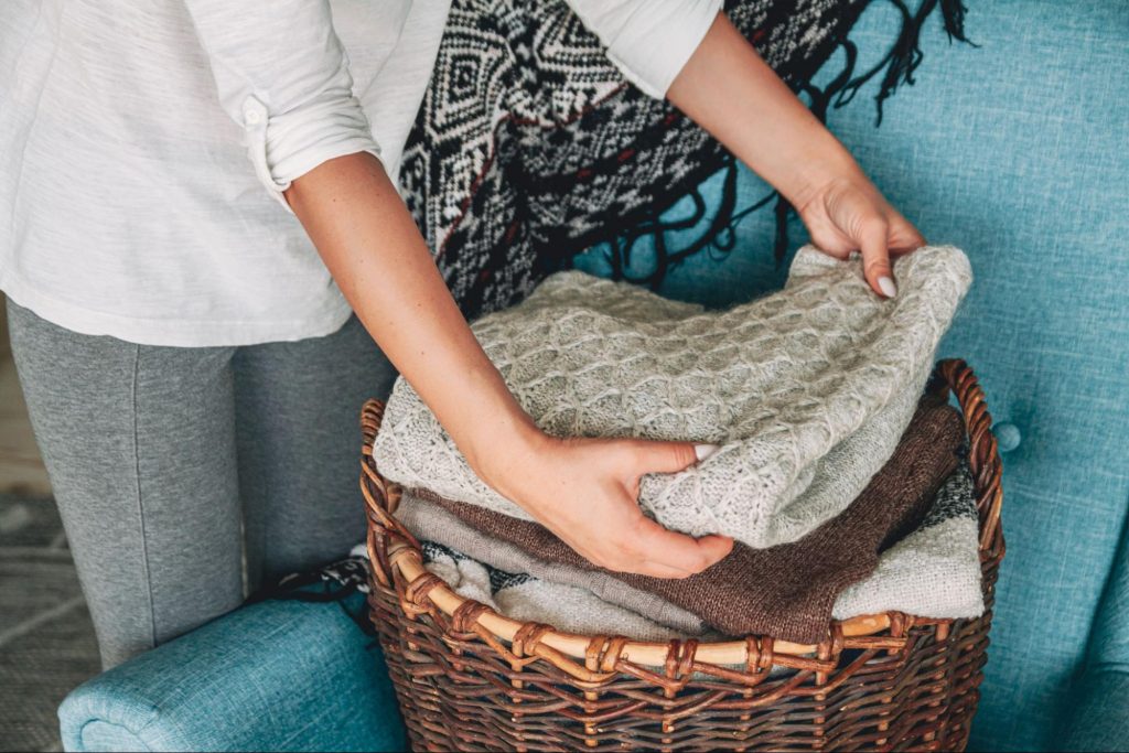 Woman folding cozy blankets in preparation for holiday guests.
©perfectlab