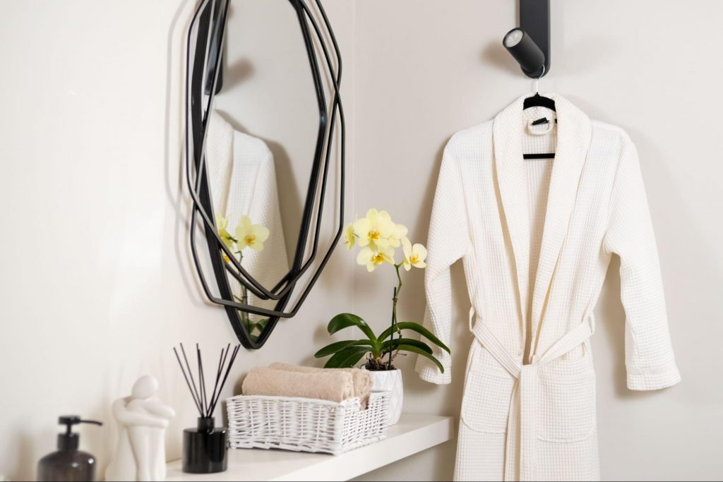 Cozy white bathrobe and spa essentials displayed in a guest room for holiday visitors.
©Rimidolove
