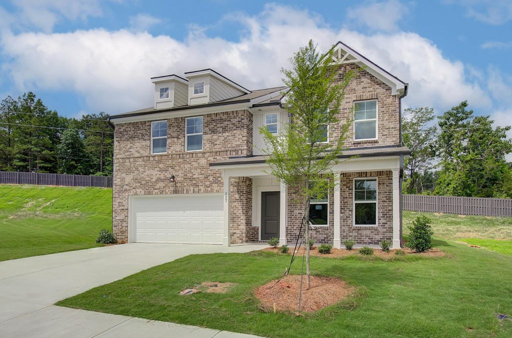 Front exterior of an Alcovy Village home featuring brick accents and two-car garage.