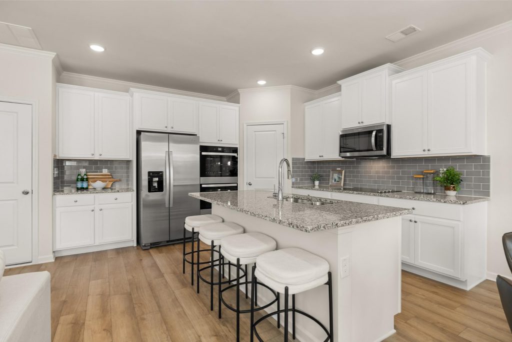 Gourmet kitchen at Alcovy Village with granite countertops, large island, and stainless steel appliances. 