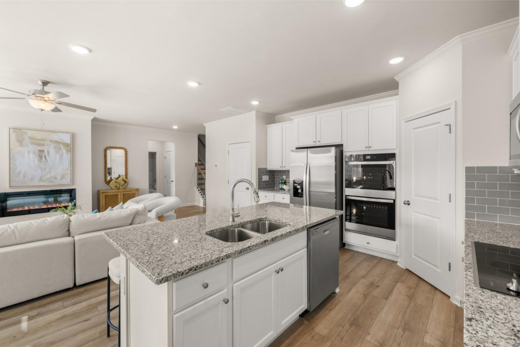 Gourmet kitchen at Alcovy Village with granite countertops, large island, and stainless steel appliances.
