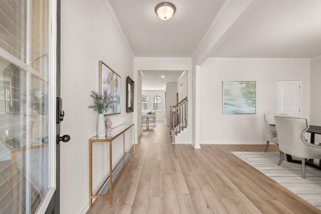 Open-concept living area at Alcovy Village with dining room, large windows, and modern fireplace.