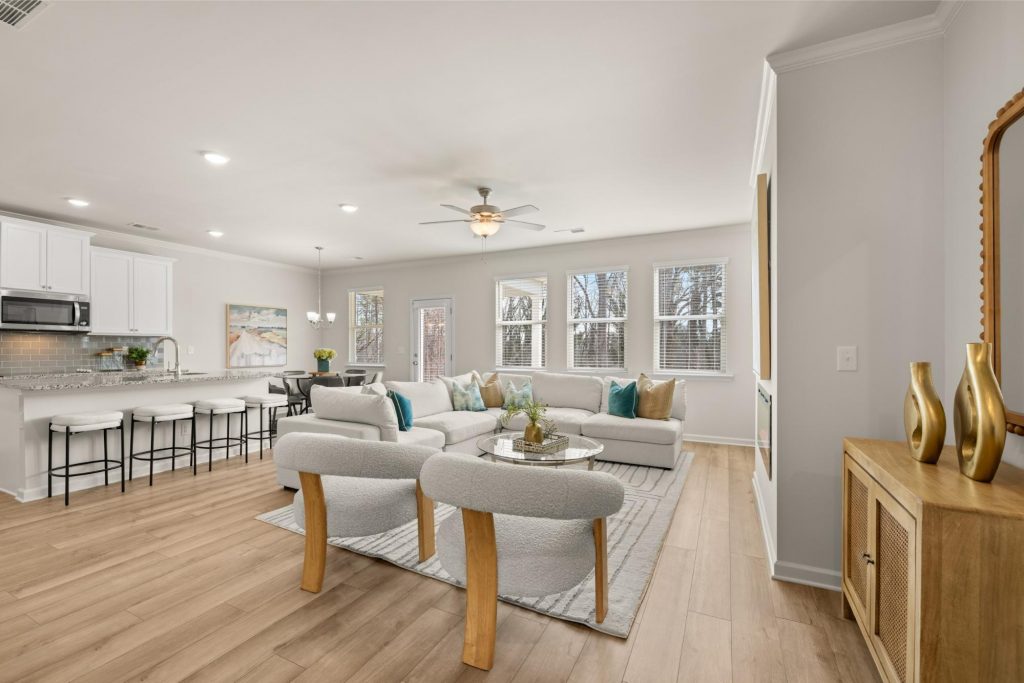Open-concept living area at Alcovy Village with dining room, large windows, and modern fireplace.