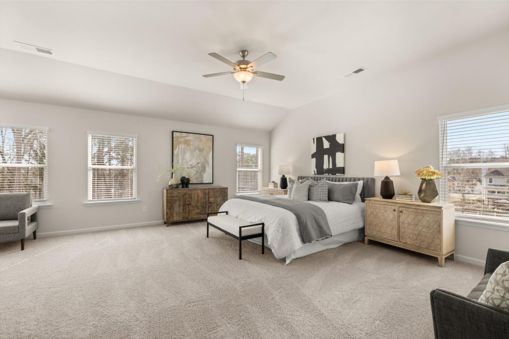 Primary suite at Alcovy Village with sitting area, spacious bedroom, and ensuite bath with garden tub.