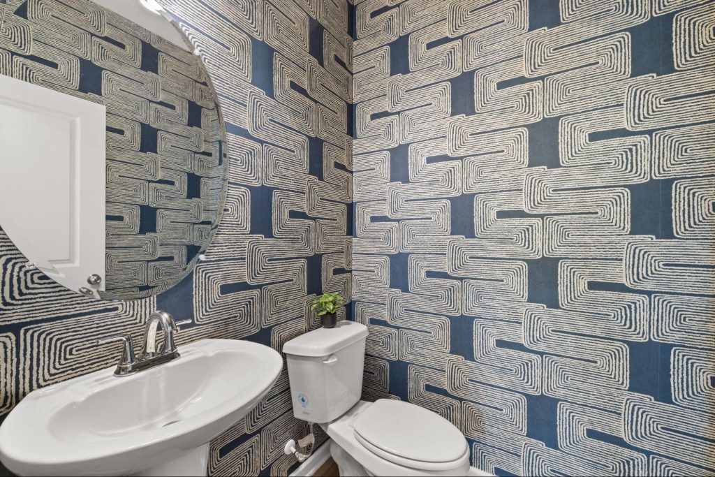 Rockhaven bathroom with blue and white patterned wallpaper and warm décor accents.