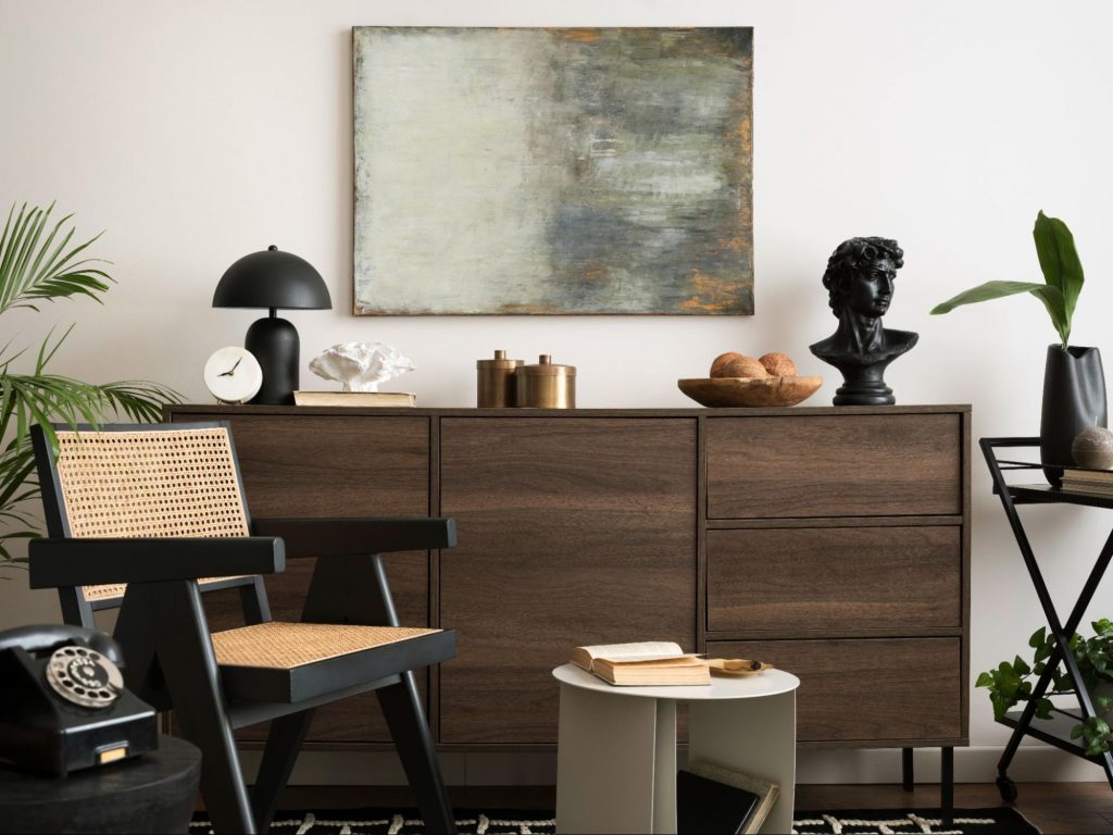 Dark-toned wood dresser with chair and decorative accents in a styled interior.
©LightFieldStudios