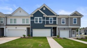 Row of modern townhomes in an HOA community with maintained landscaping and shared exterior design