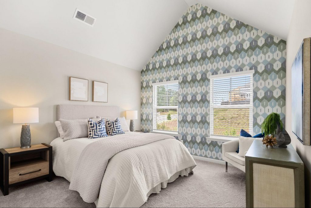 Bedroom with bold wallpaper accent wall in a beautifully decorated new home