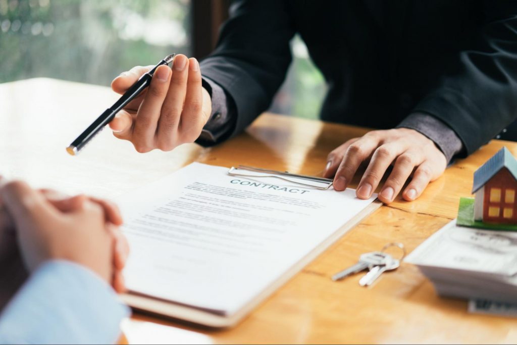 Close up of home buyer signing a real estate purchase agreement and mortgage contract with a pen.
© ijeab