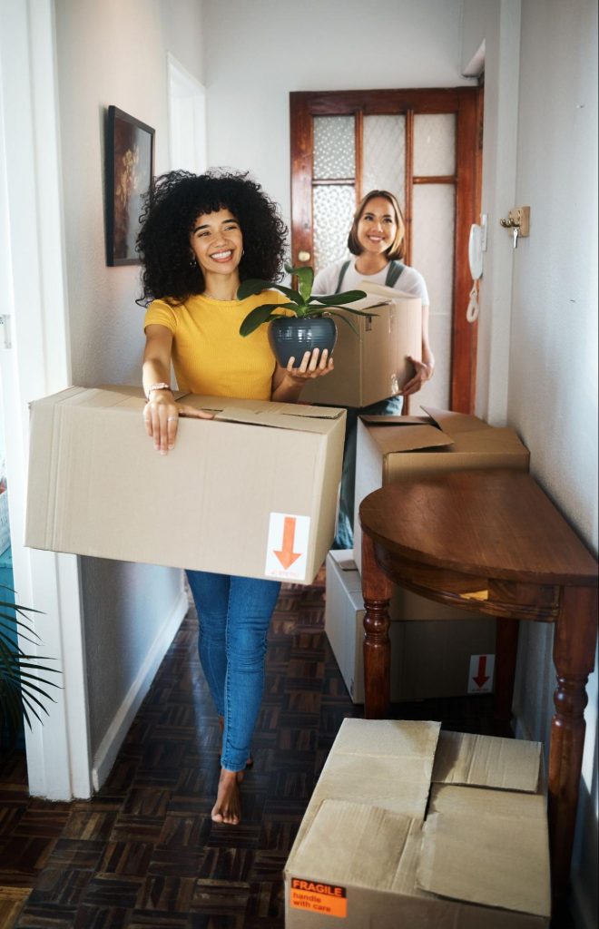 two people walking into their new home with moving boxes ©PeopleImages